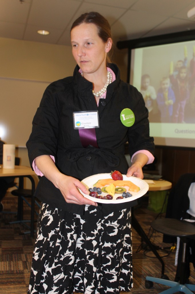 Courtney Kennedy, Nutrition and Education Manager and head of the Cooking Matters program for Good Shepherd Food Bank, shows a fun way to get kids to eat healthy with a clown face made of fruit.