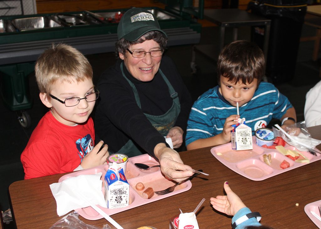 Jane Bell hands out "I love Maine milk" stickers during lunch.